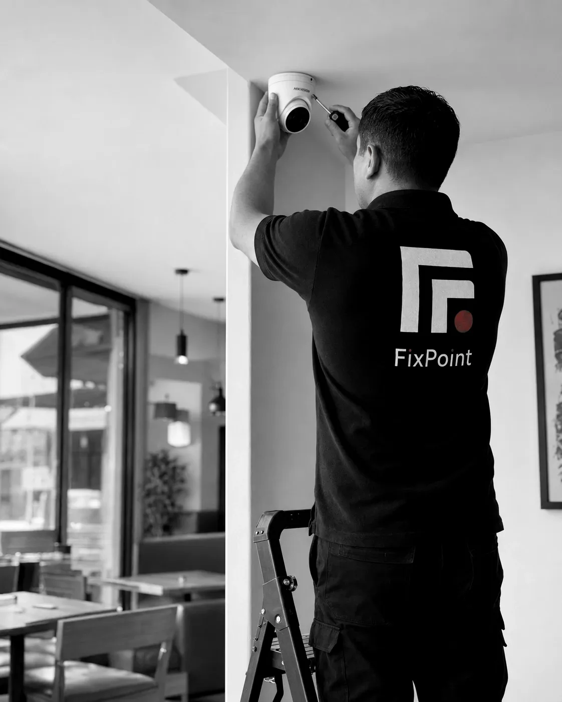 Técnico de FixPoint ajustando con destornillador una cámara domo montada en el techo